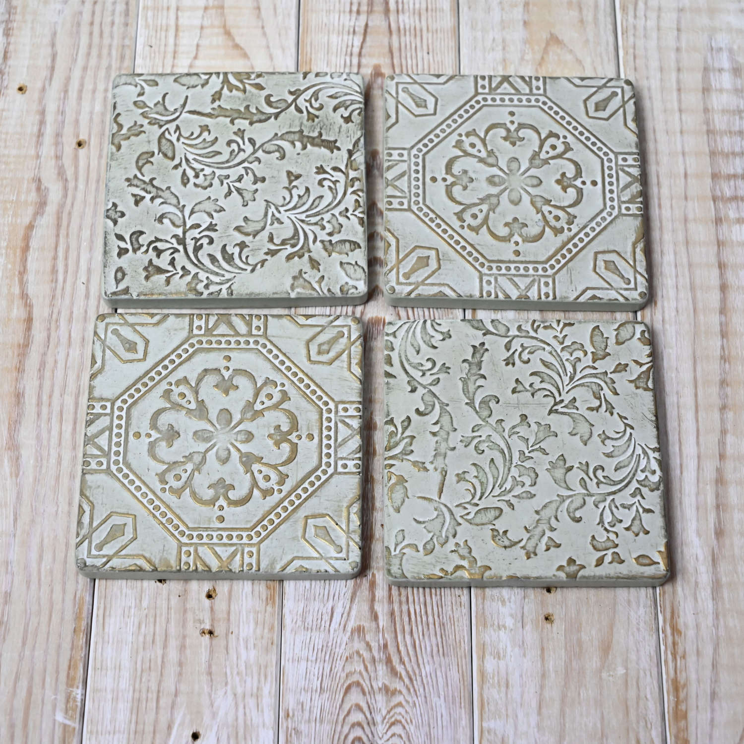 Set of four embossed bronze coasters